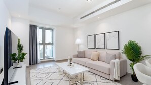 A modern living room with a sofa, coffee table, and potted plants. - Magnificent 2BR at Dubai Marina (Dubai)
