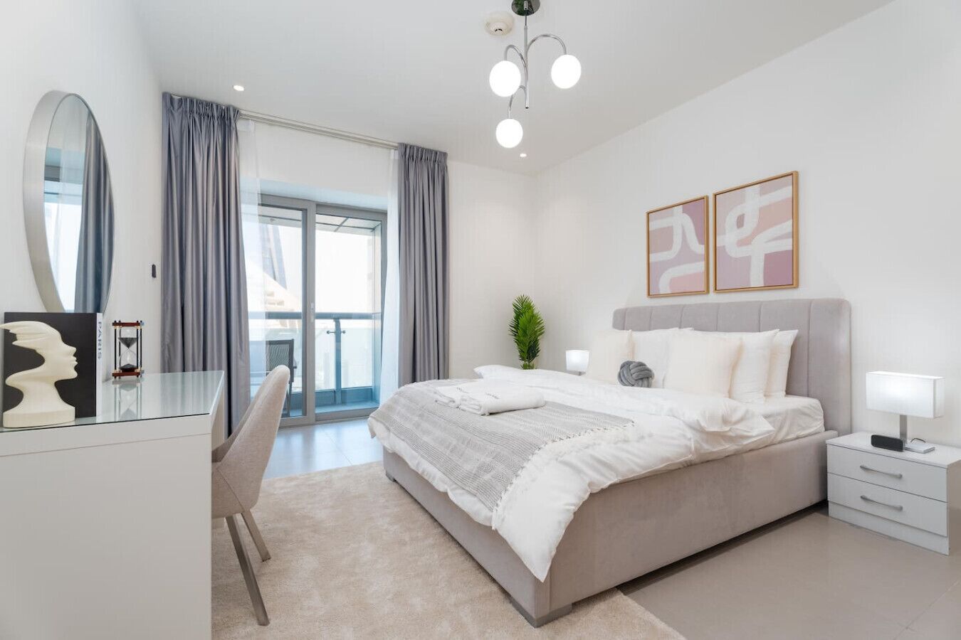 Un dormitorio moderno con una cama grande, un escritorio y un balcón.