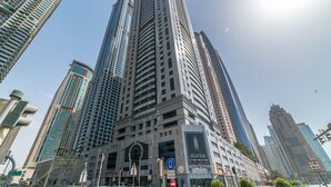 A high-rise building with a prominent entrance and multiple floors. - Magnificent 2BR at Dubai Marina (Dubai)
