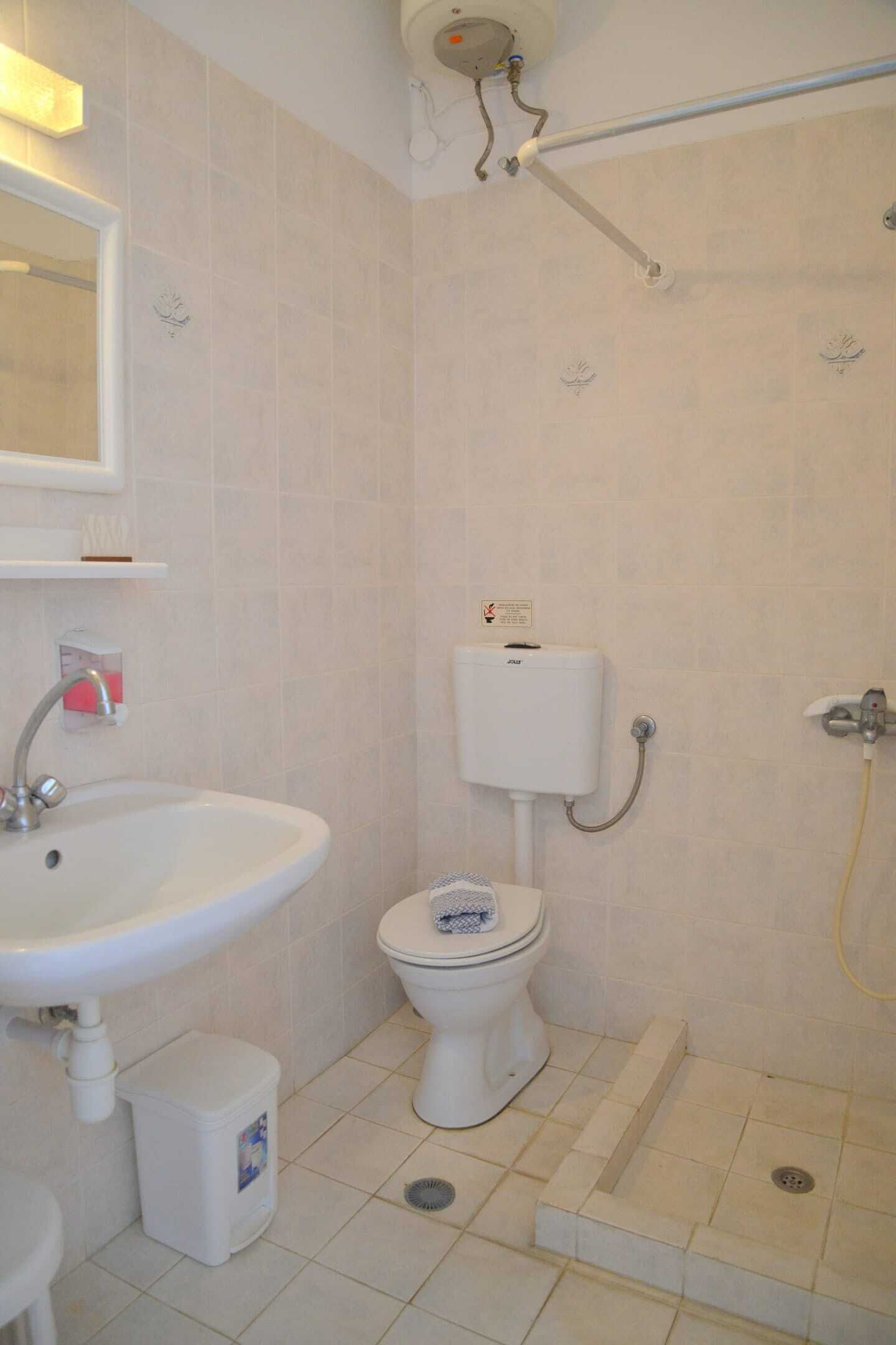 A bathroom with a sink, toilet, and shower.