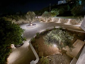 Un espace extérieur aménagé avec un bassin circulaire, des murs en pierre et des arbres.