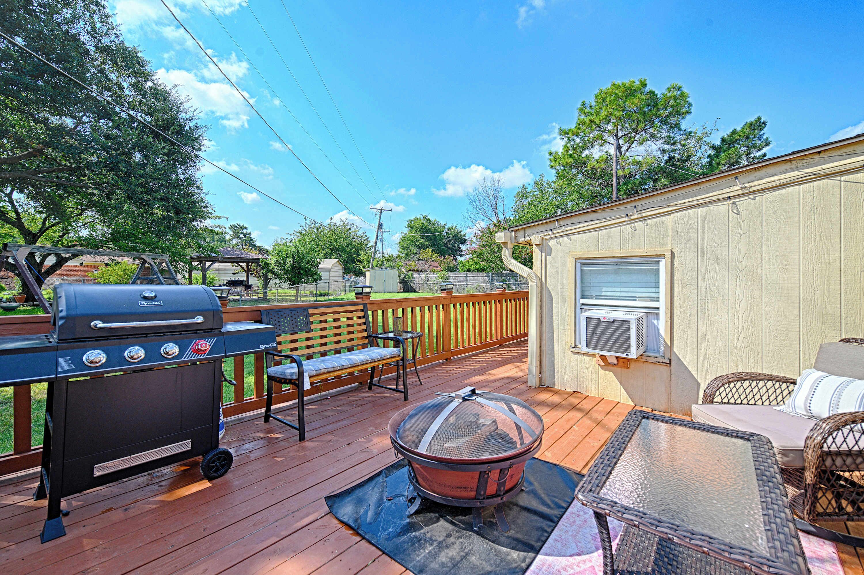 A deck with a grill, outdoor seating, and a fire pit.