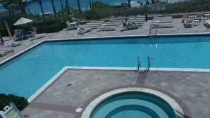 Une piscine avec des chaises longues et un jacuzzi.