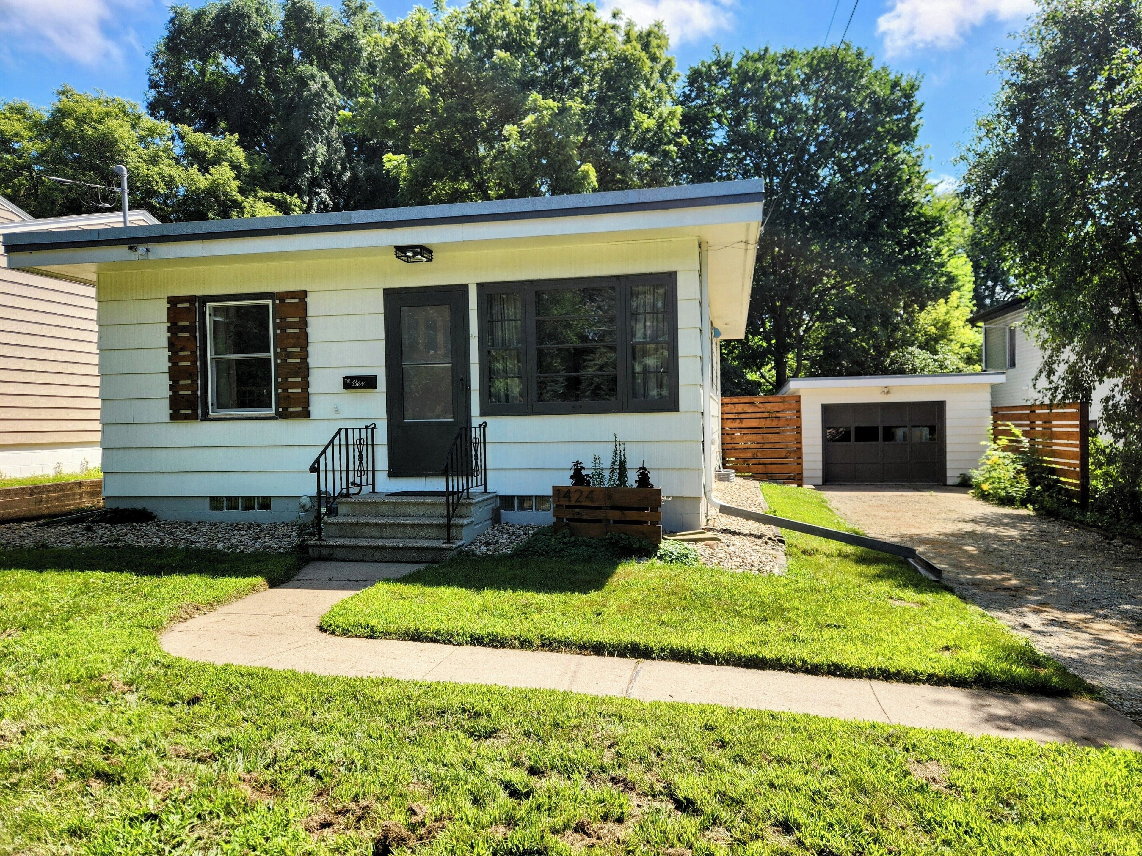 A single-story house with a front porch, a garage, and a well-maintained lawn.