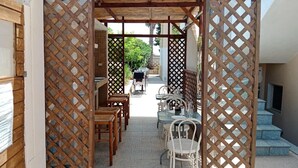 An outdoor dining area with wooden lattice partitions, tables, and chairs. - Accommodation in Villa Cristina (Puglia)