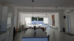 A spacious kitchen with a central island, modern pendant lights, and a view to the outside. - Modern villa with a private pool (Bogišići)