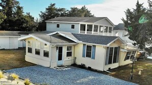 A two-story house with a covered patio area. - Escape to this charming beach cottage along the coast of Broadkill Beach (Milton)