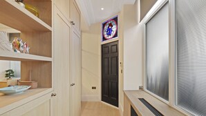 Una cocina moderna con armarios de madera, una puerta negra y un ventanal con vidrieras.