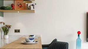 Una cocina moderna con una isla de madera, luces colgantes y un taburete de bar.