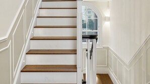 Un escalier avec des murs blancs et des marches en bois.