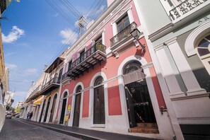 Vista de una calle con edificios que tienen ventanas y balcones arqueados.