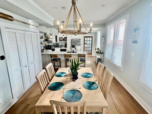 A dining area with a wooden table, chairs, and a chandelier.