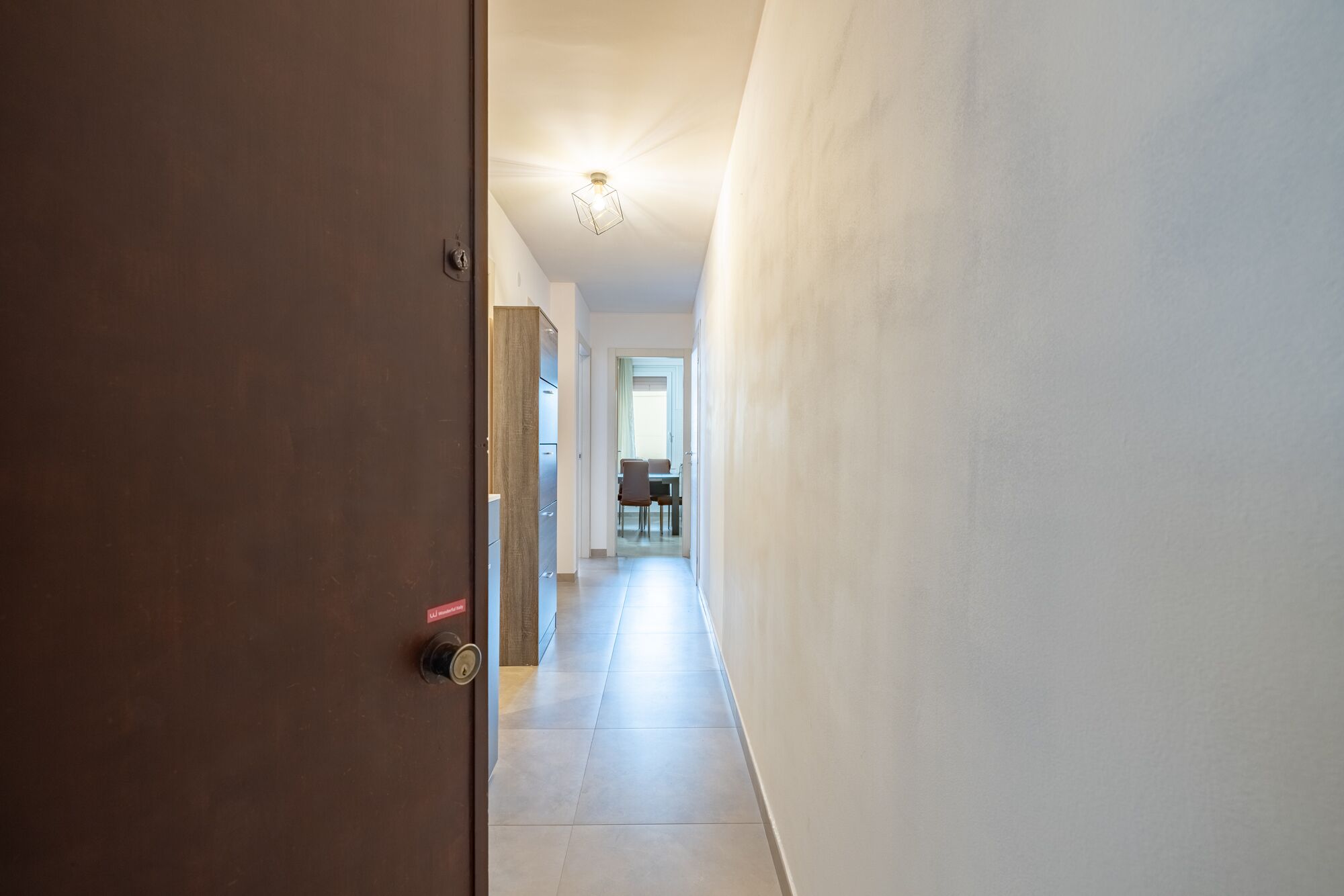 A hallway leading to a dining area with a table and chairs.