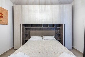 Un dormitorio con una cama, un cabecero y un cuadro en la pared.