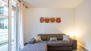 A modern living room with a sectional sofa, a small table, and a wall-mounted artwork.