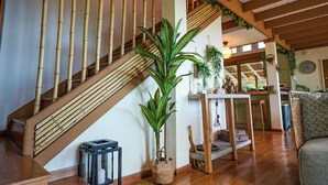 A staircase with bamboo railings, a potted plant, a lantern, and a wicker basket.