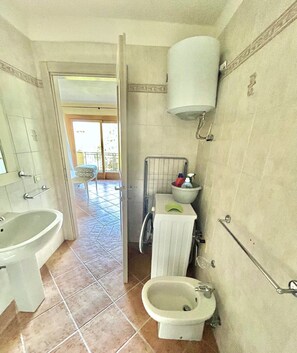 A bathroom with a sink, bidet, and toilet.