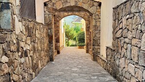 Un estrecho callejón empedrado con un arco de piedra que da paso a un edificio.