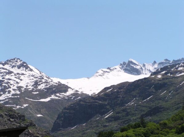 A mountain landscape with snow-capped peaks and a clear sky.