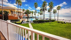 Un resort con piscina, palmeras y vista al océano.