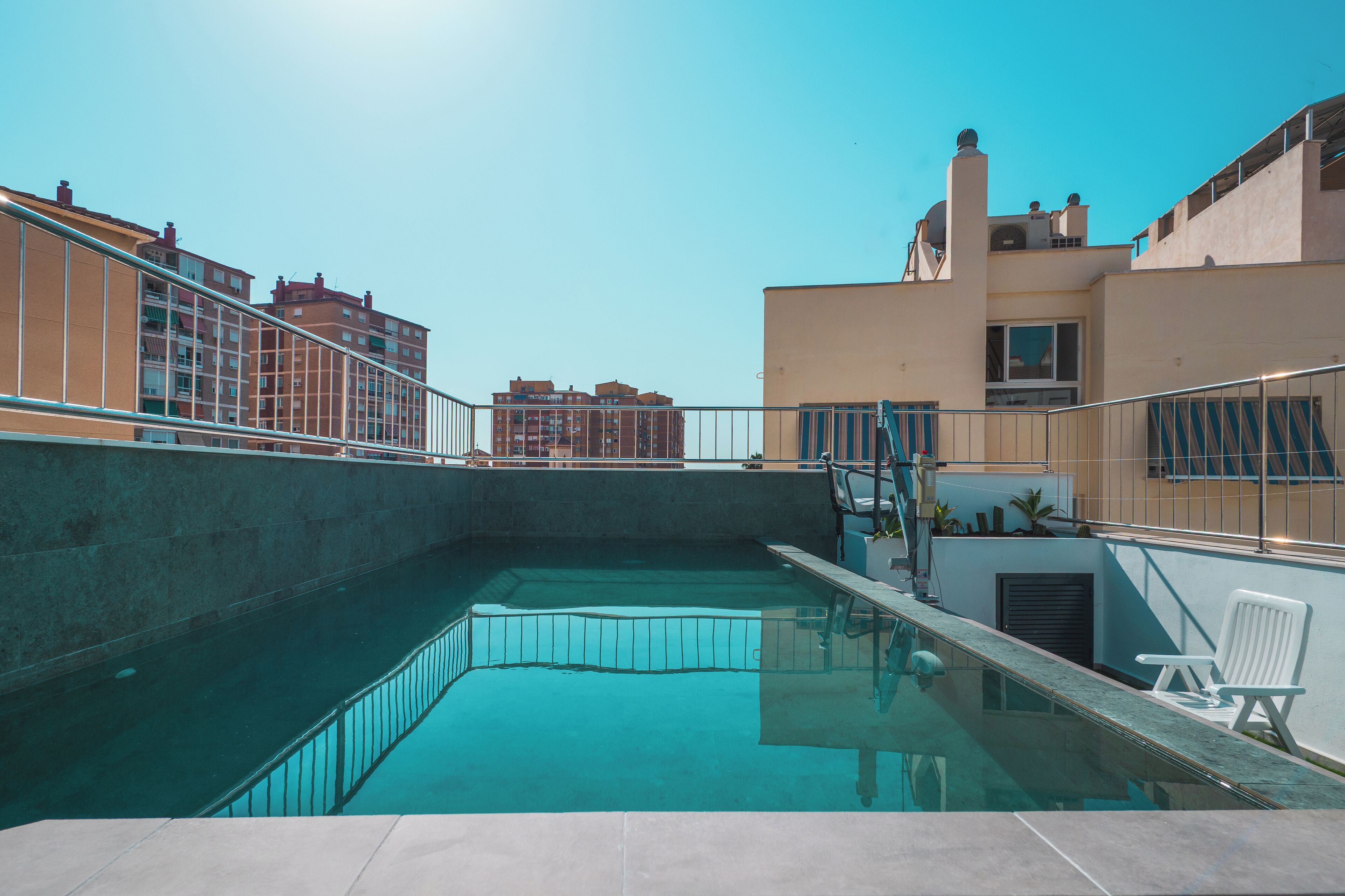 室外游泳池，池畔遮阳伞，日光浴躺椅