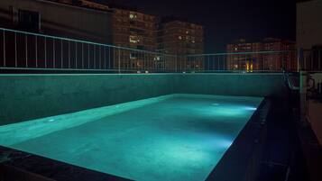 Een buitenzwembad, parasols voor strand/zwembad