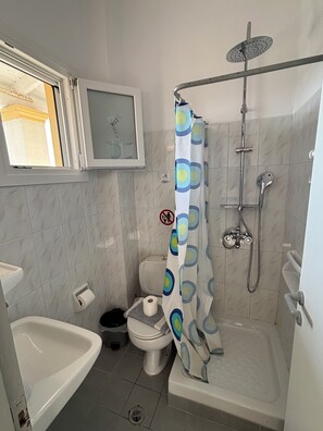 A bathroom with a shower, toilet, and sink. - DOLPHIN APARTMENTS & STUDIOS (Corfu)
