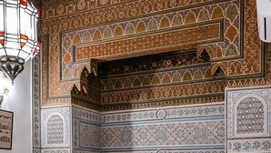 A room with a traditional Moroccan design, featuring intricate tile work on the walls and a red sofa with cushions. - Beautiful 2-bedroom house "19th century Douiria" in Marrakech-with large terrace (Marrakech)