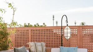 A sun lounger with a striped pillow, a wooden fence, and a hanging lantern in the background. - Beautiful 2-bedroom house "19th century Douiria" in Marrakech-with large terrace (Marrakech)