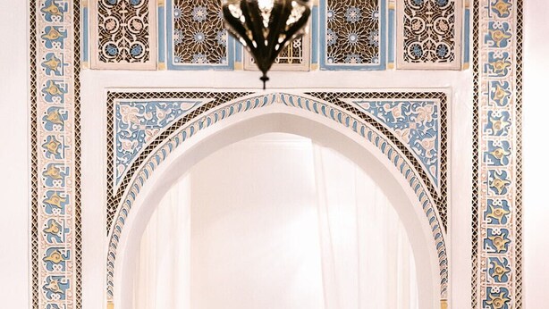 An archway leading to a kitchen with a tiled backsplash and hanging utensils. - Beautiful 2-bedroom house "19th century Douiria" in Marrakech-with large terrace (Marrakech)