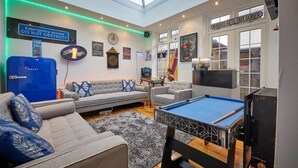 A modern living room with a pool table, sofas, and a blue Bosch refrigerator. - The View Old Coastguard Cottage (Spanish Battery)
