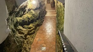 Un escalier avec un mur à texture sur un côté et une rampe métallique de l’autre.