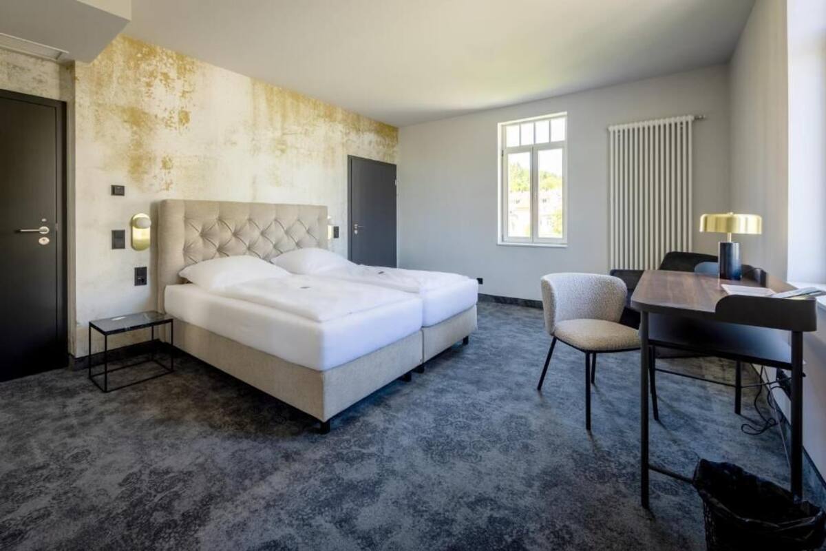 Een hotelkamer met een groot bed, een bureau en een stoel.
