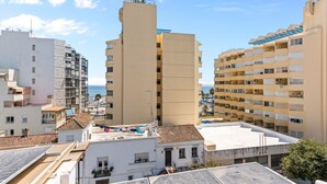 Un immeuble à plusieurs étages, doté de balcons, d’un toit plat et offrant une vue dégagée sur la mer.