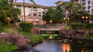 A hotel courtyard with a pond, rocks, and a bridge. - Westin Nanea in Lahaina, Maui. 2 bedroom, 2 bathroom (Lahaina)