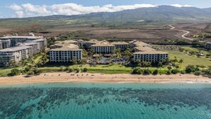A resort with multiple buildings, a beach, and a mountainous backdrop. - Westin Nanea in Lahaina, Maui. 2 bedroom, 2 bathroom (Lahaina)