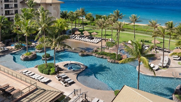 A resort with a large pool area, palm trees, and a view of the ocean. - Westin Nanea in Lahaina, Maui. 2 bedroom, 2 bathroom (Lahaina)