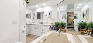 A modern bathroom with a double sink, large mirror, and cabinets.