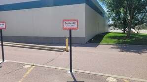 A parking area with signs indicating Suite #2 reserved for Airbnb and Vrbo.