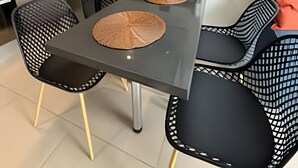 A modern kitchen with a central island, black chairs with a geometric pattern, and a wooden cutting board on the island. - Collection R 5 MONEDA 2 Presidencial  (Santiago)