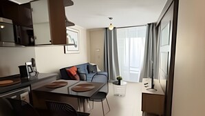 A modern kitchen with a dining area, a sofa, and a small table with chairs. - Collection R 5 MONEDA 2 Presidencial  (Santiago)