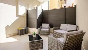 A modern outdoor seating area with wicker furniture and a glass coffee table. - Suite 53 Campofiore - with outdoor patio (Verona)
