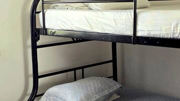 A bunk bed with two levels, each with a mattress and pillow.