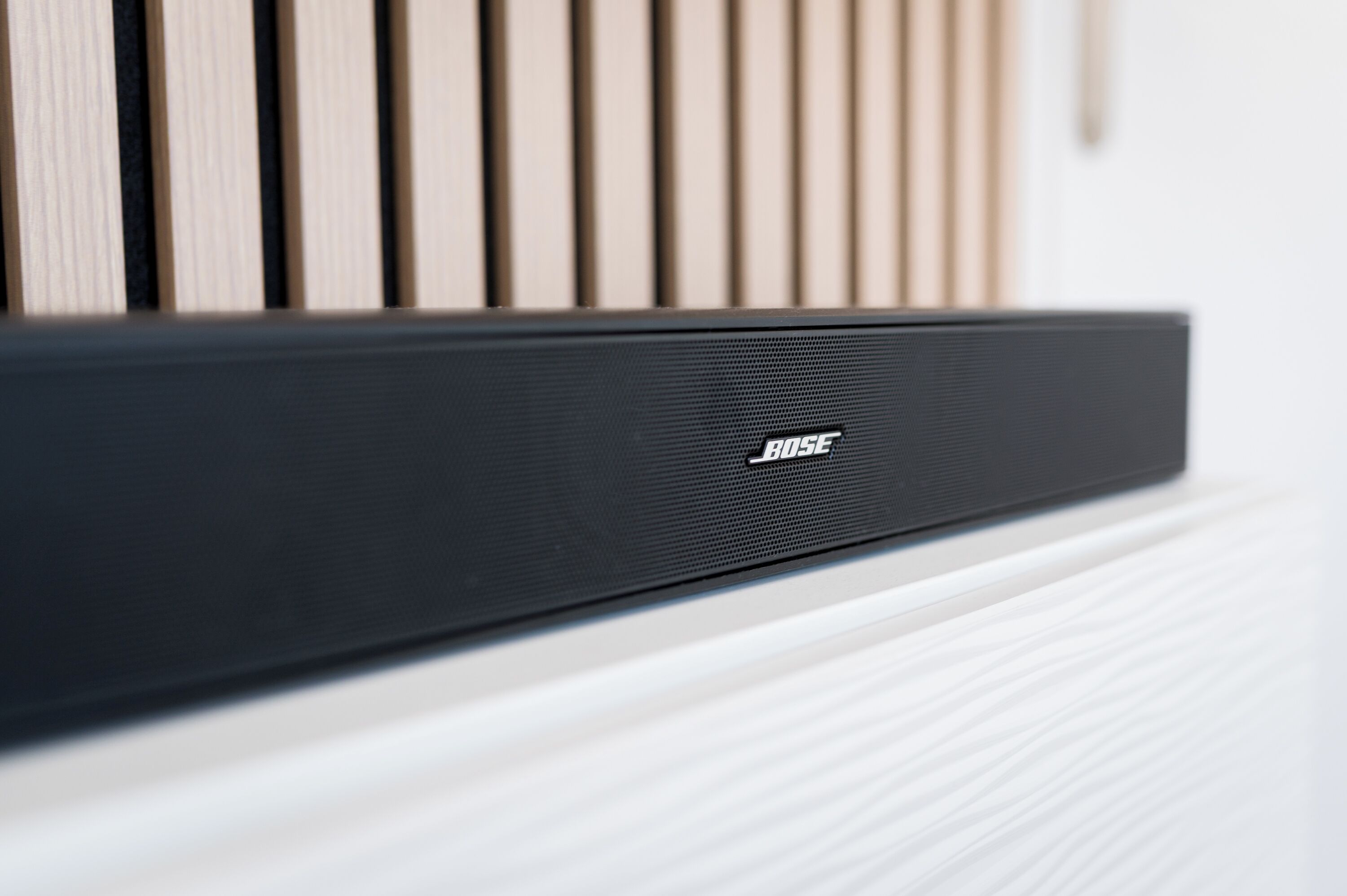 Een zwarte speaker met het merk 'BOSE' op een wit oppervlak.