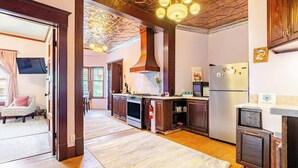 A kitchen with wooden cabinets, a stove, a refrigerator, and a chandelier.