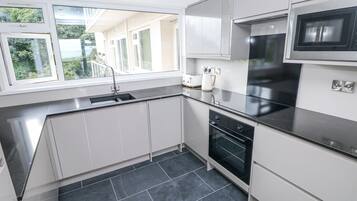 A modern kitchen with a built-in oven, a microwave, and a sink.
