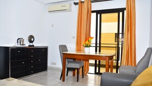Een moderne woonkamer met een eettafel, een bank en een kast.