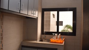 Een moderne keuken met een raam, een spoelbak en kastjes.