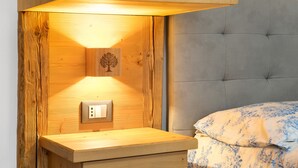 Ein Nachttisch aus Holz mit einer Wandleuchte und einer Steckdose.