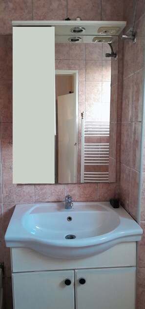 A bathroom with a white sink, a mirror, and a cabinet. - Great Location with Balcony and the best View for up to 5 guests! (Sarajevo)